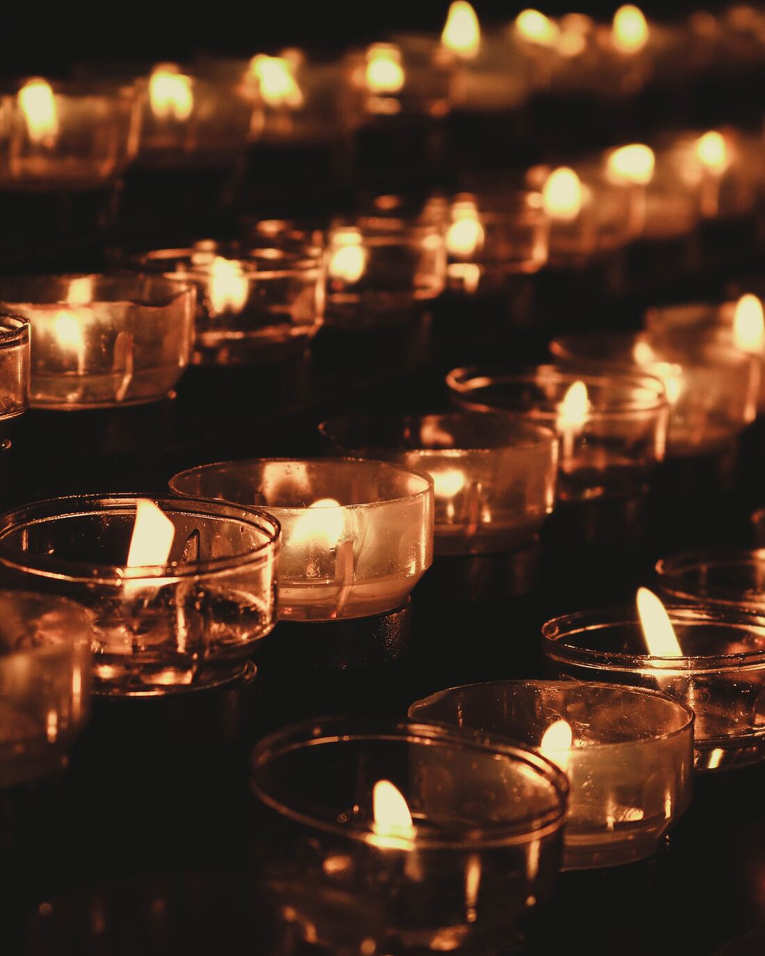 Rows of candles burning in a darkened hall